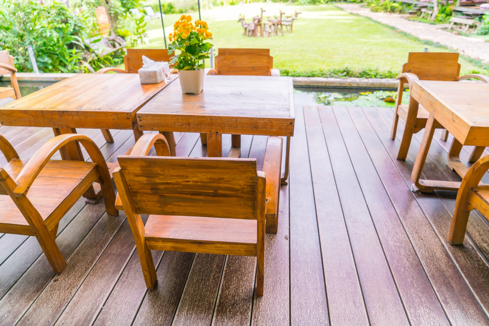 Una terraza de madera con mesas y sillas.