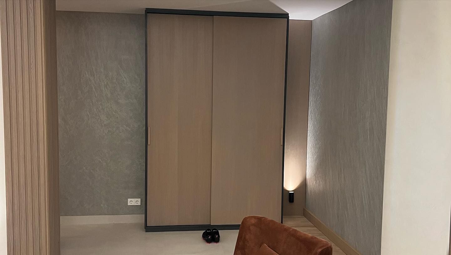 Una sala de estar con un sofá y un gran armario.