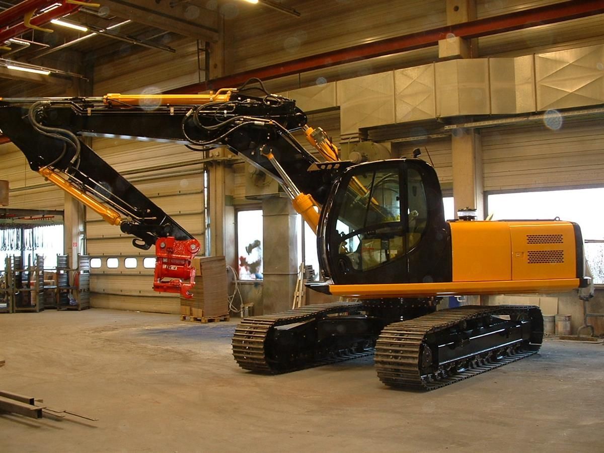 Ein gelb-schwarzer Bagger steht in einem großen Gebäude