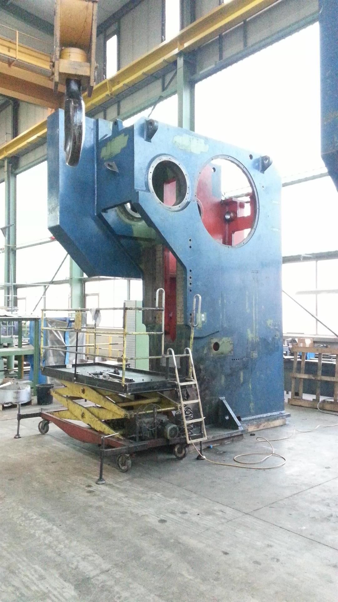 In einer Fabrik steht eine große Maschine, an der eine Leiter befestigt ist.