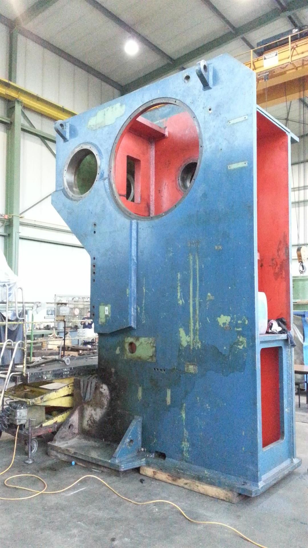 In einer Fabrik steht eine große blau-rote Maschine.