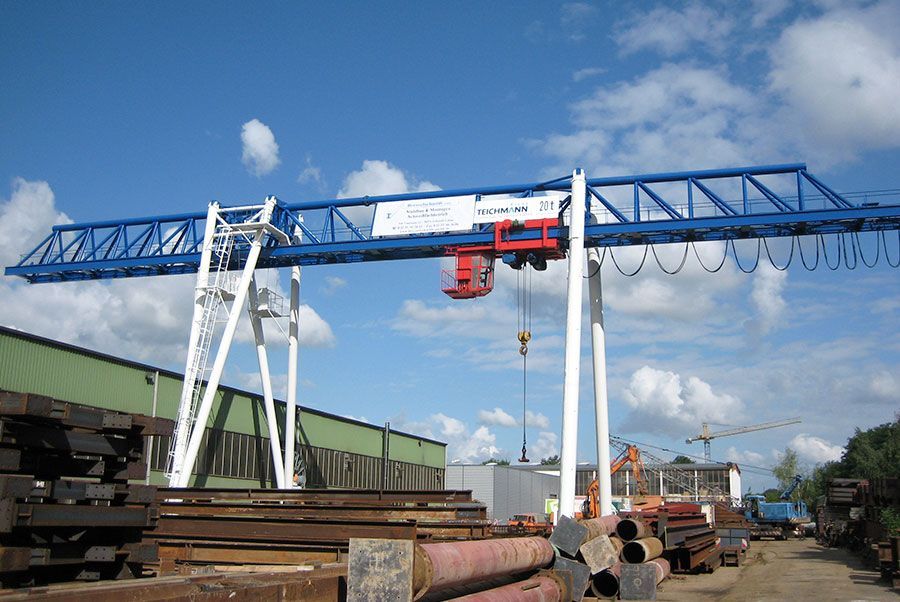 Ein blau-weißer Kran sitzt auf einem Stapel Rohre.