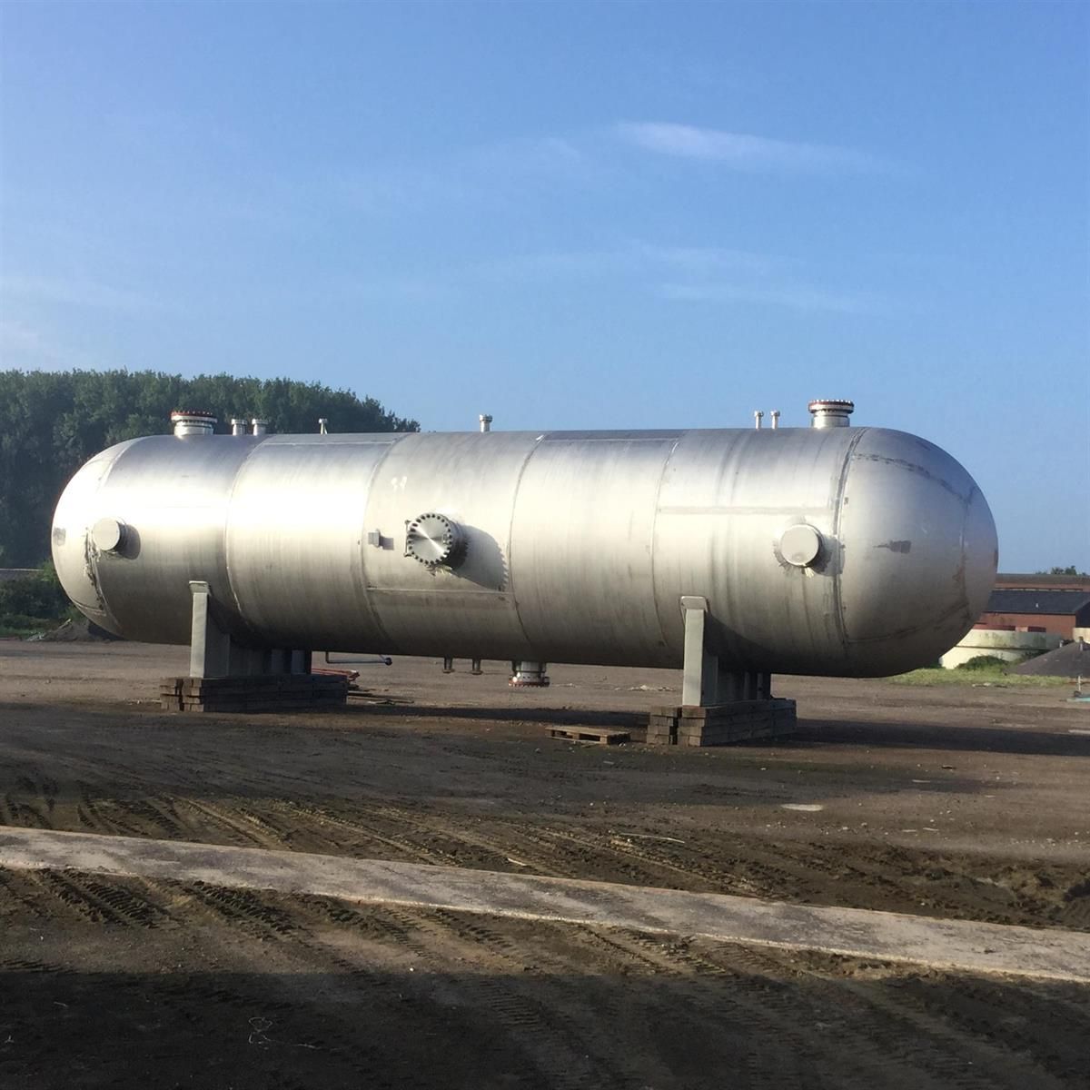 Auf einem Feld steht ein großer Edelstahltank.
