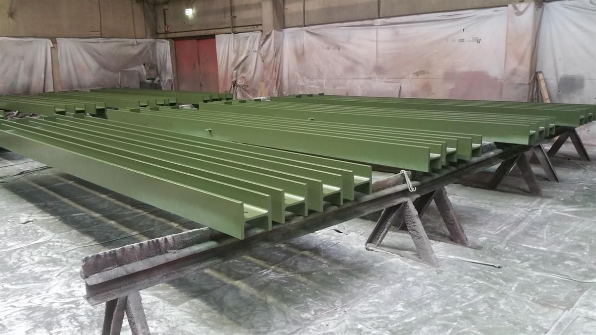 Ein Haufen grüner Metallteile liegt übereinander auf einem Tisch.