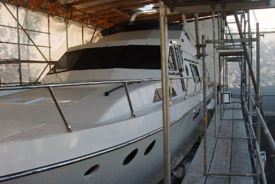 Ein großes weißes Boot liegt unter einem Gerüst