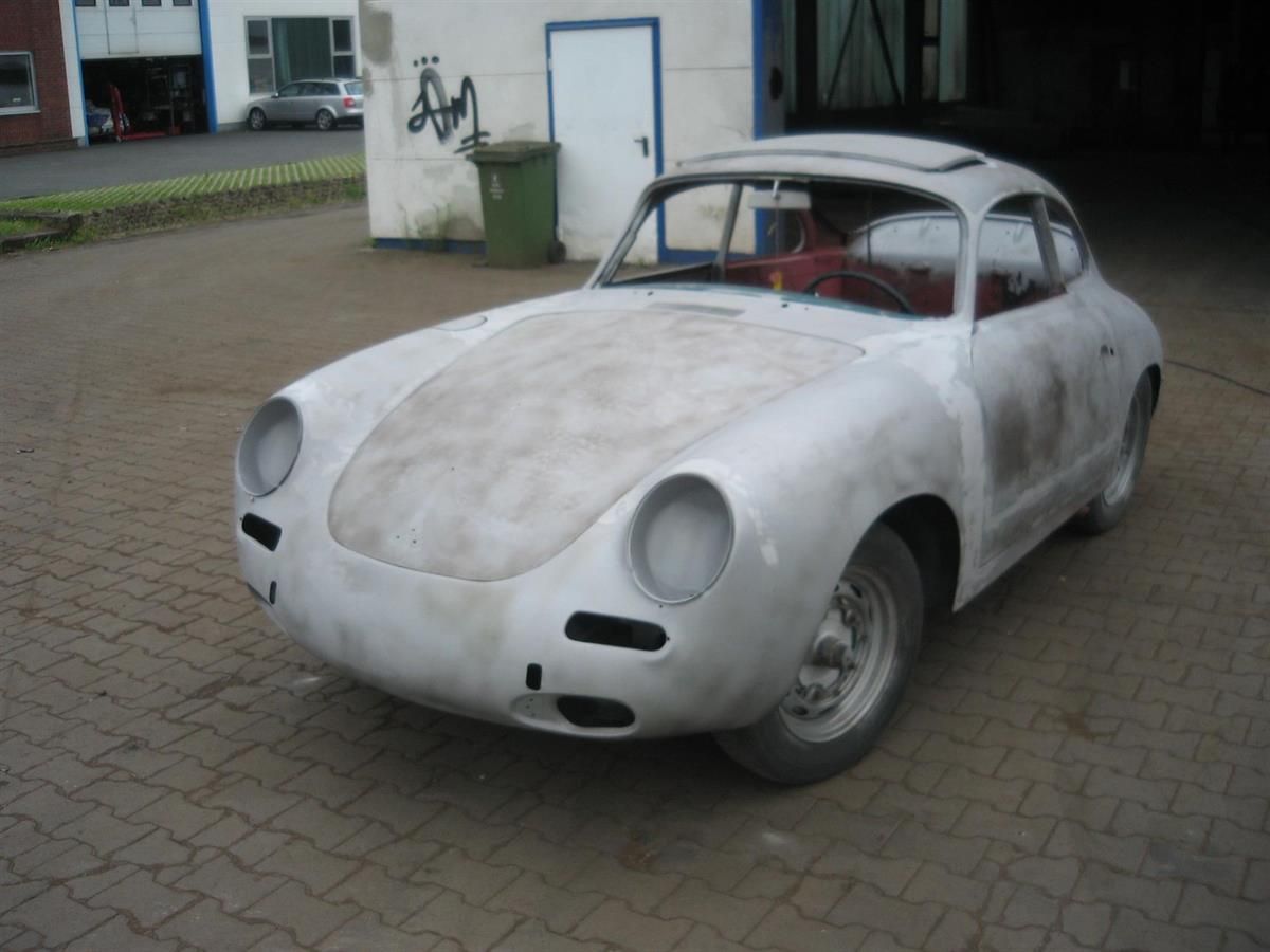 Ein weißes Auto steht vor einer Garage