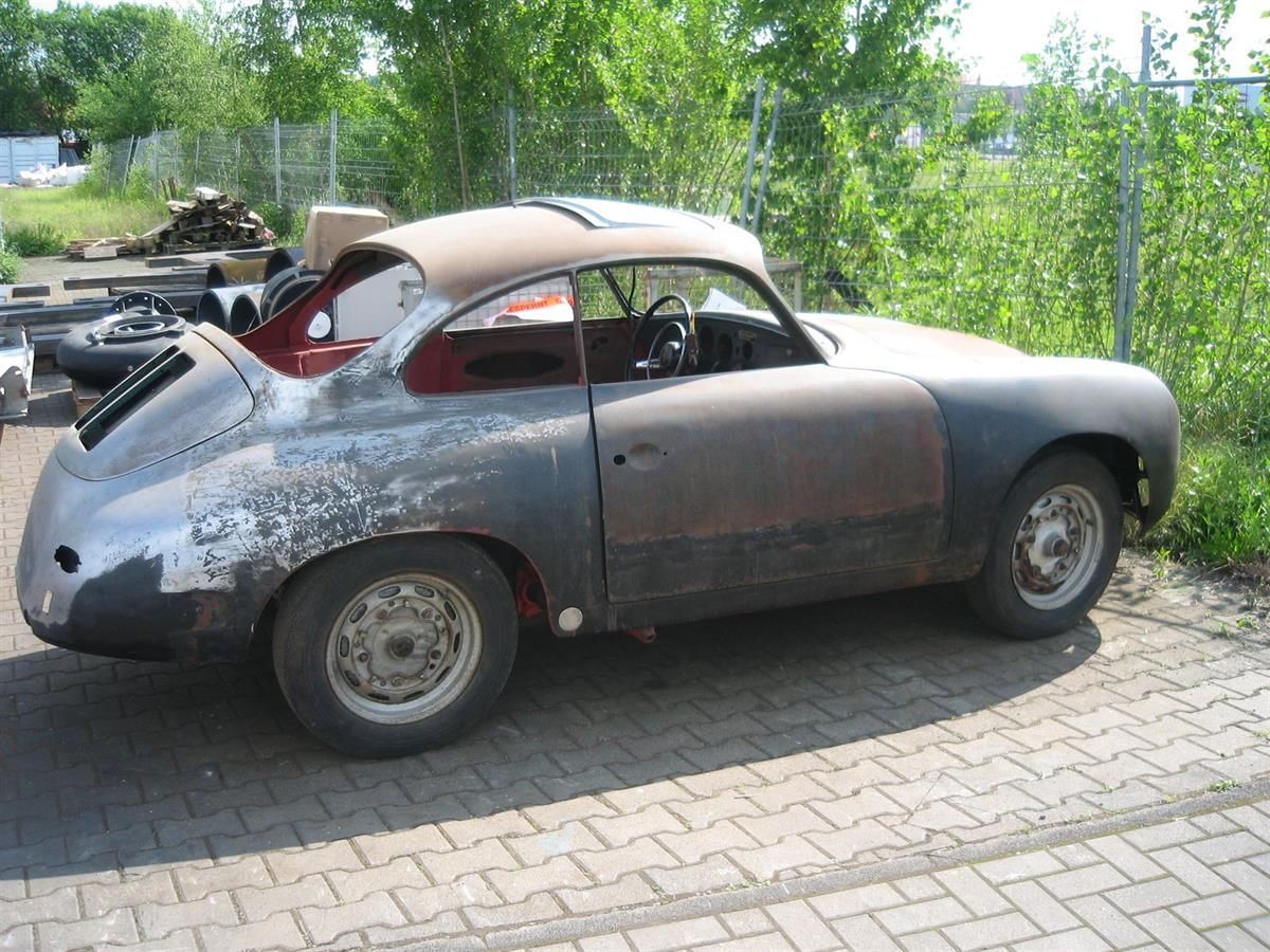 Ein altes rostiges Auto ist auf einer gemauerten Auffahrt geparkt