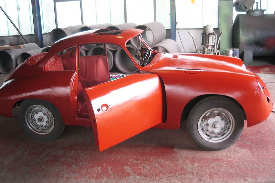 Ein rotes Auto mit offenen Türen in einer Garage