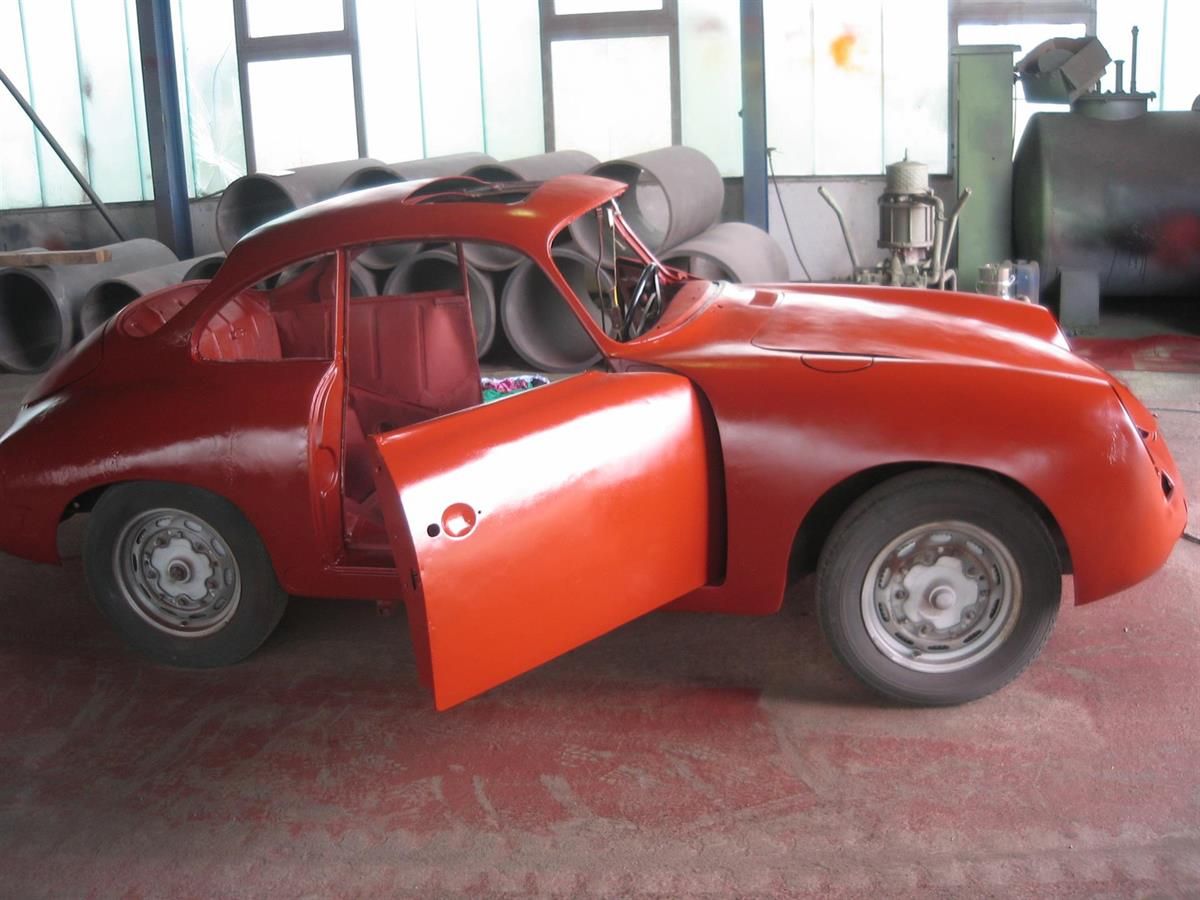Ein rotes Auto mit offenen Türen in einer Garage