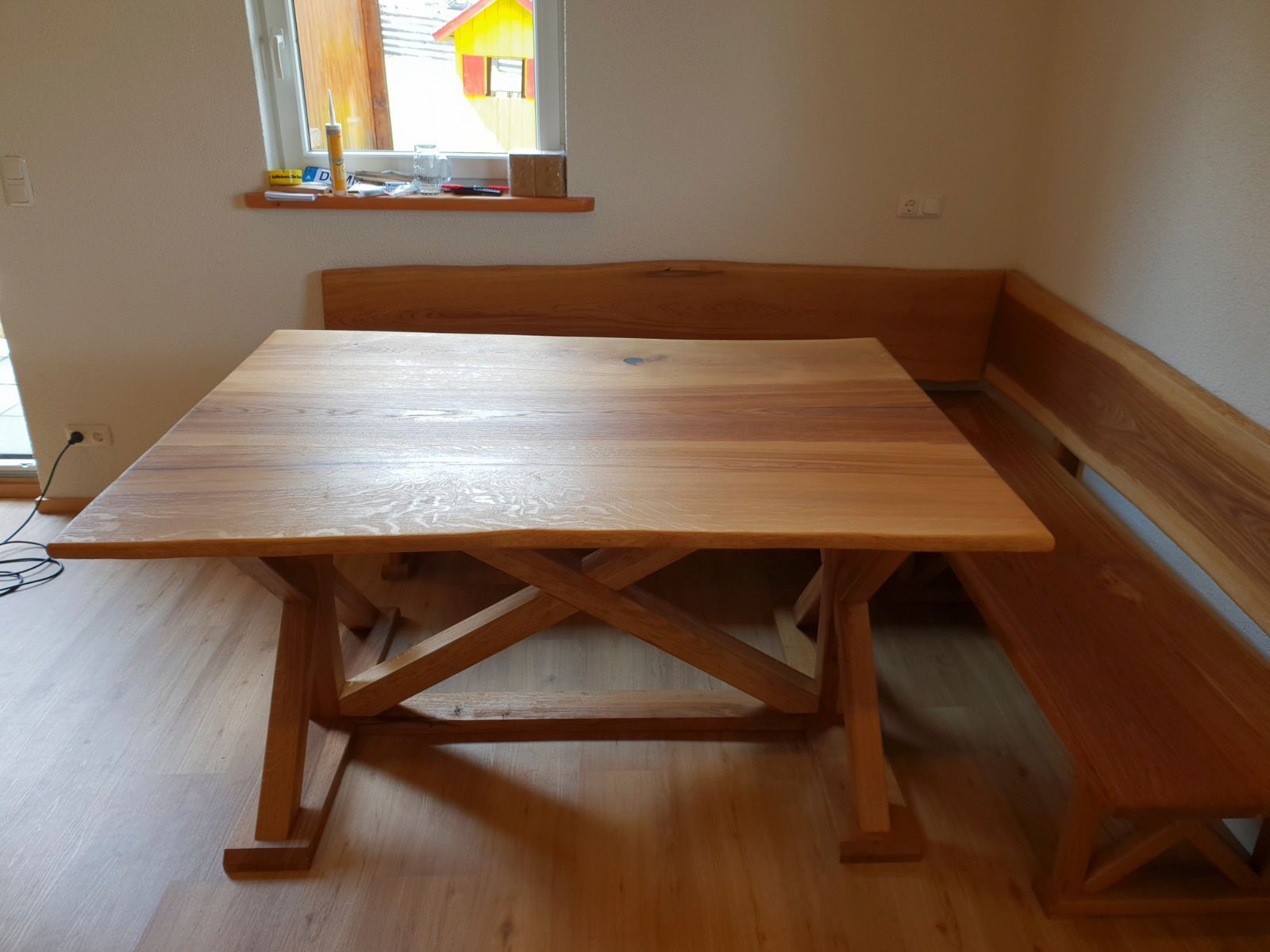 Ein Esstisch aus Holz mit angebauter Eckbank in einem Zimmer.