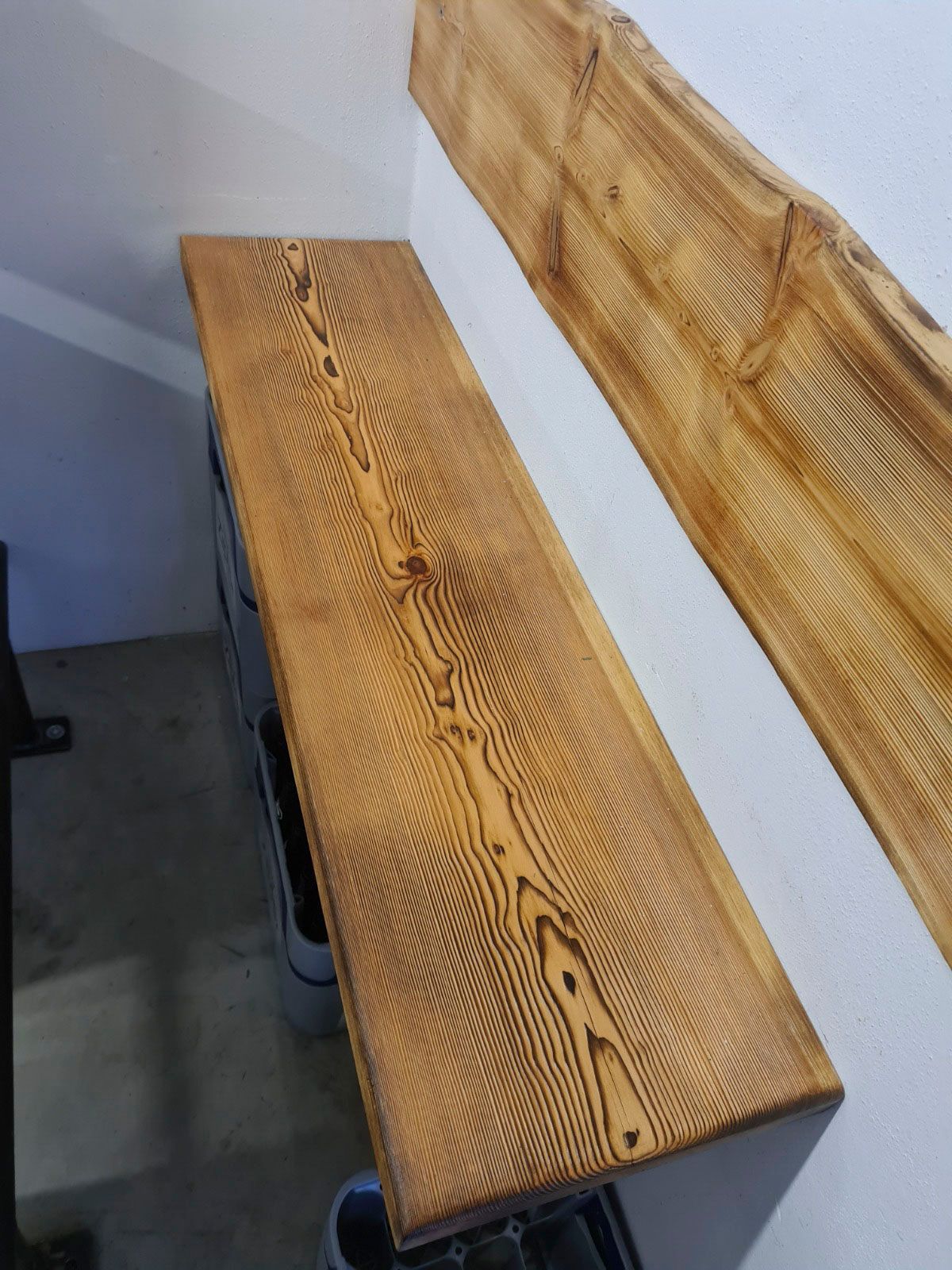 Eine Arbeitsplatte aus Holz mit einzigartiger Maserung, daneben ein Treppengeländer aus dem gleichen Holz