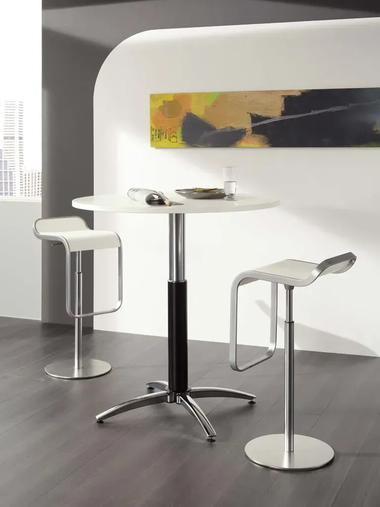 Ein Tisch und zwei Hocker in einem Raum mit einem Gemälde an der Wand