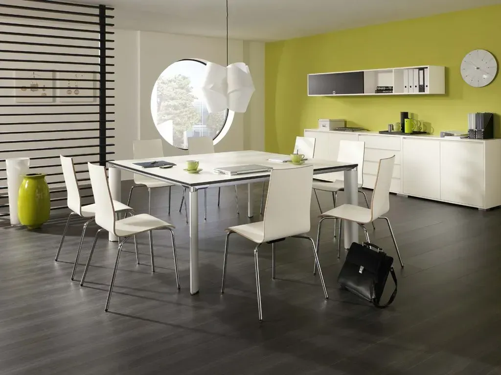 Ein Esszimmer mit einem Tisch und Stühlen und einer Uhr an der Wand