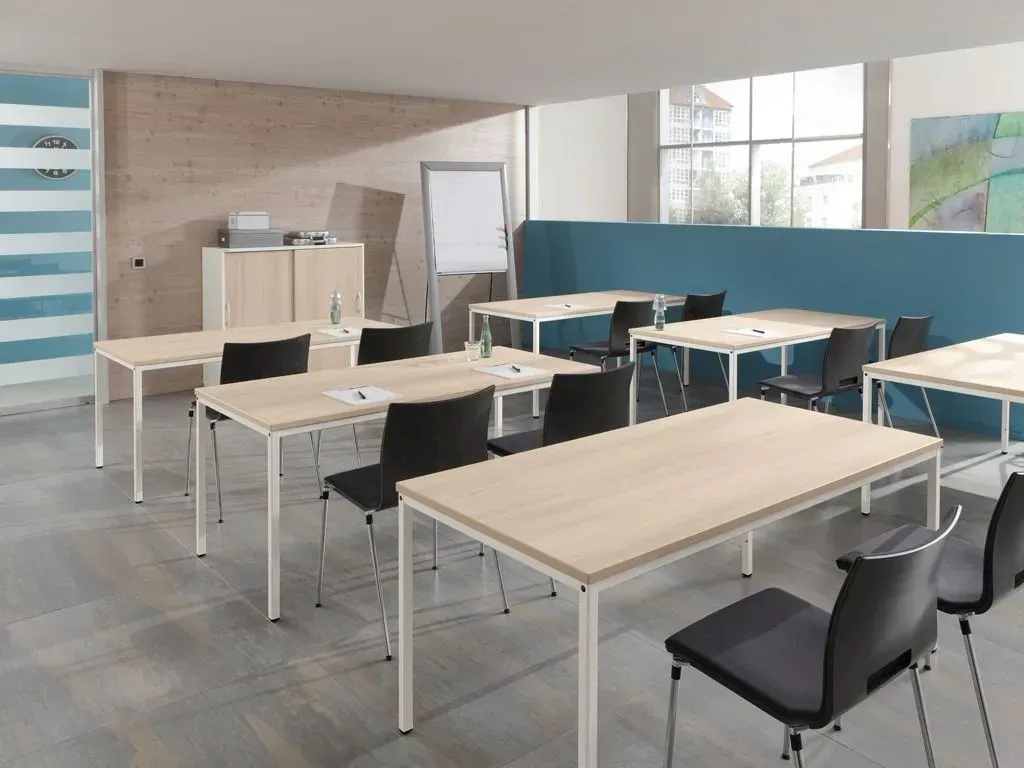 Ein Klassenzimmer mit Tischen und Stühlen darin