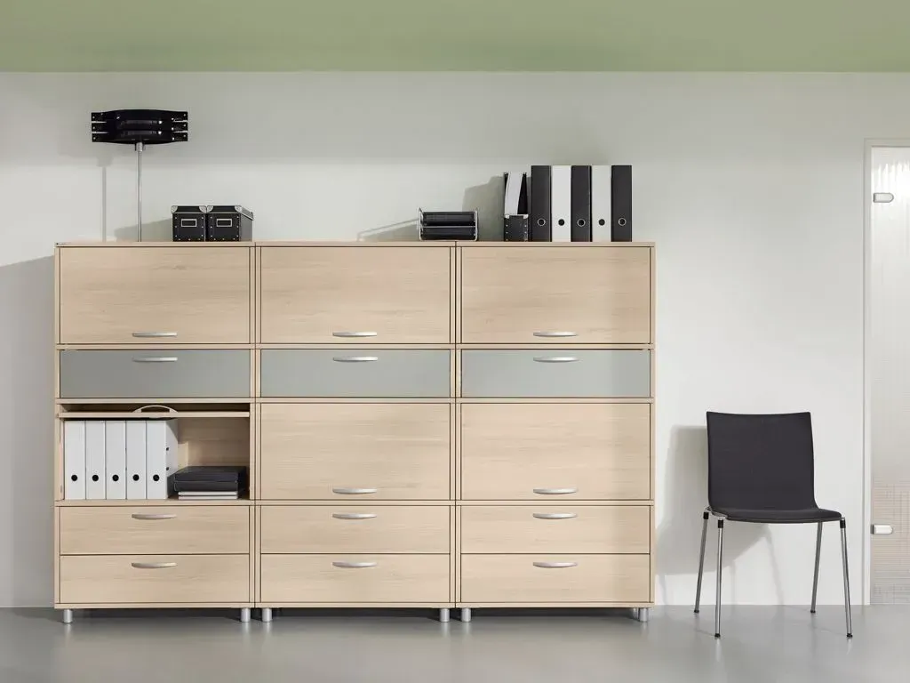 Ein Stuhl steht vor einem Regal mit Ordnern darauf