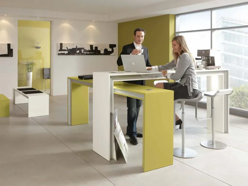 Ein Mann und eine Frau sitzen mit einem Laptop an einem Tisch.