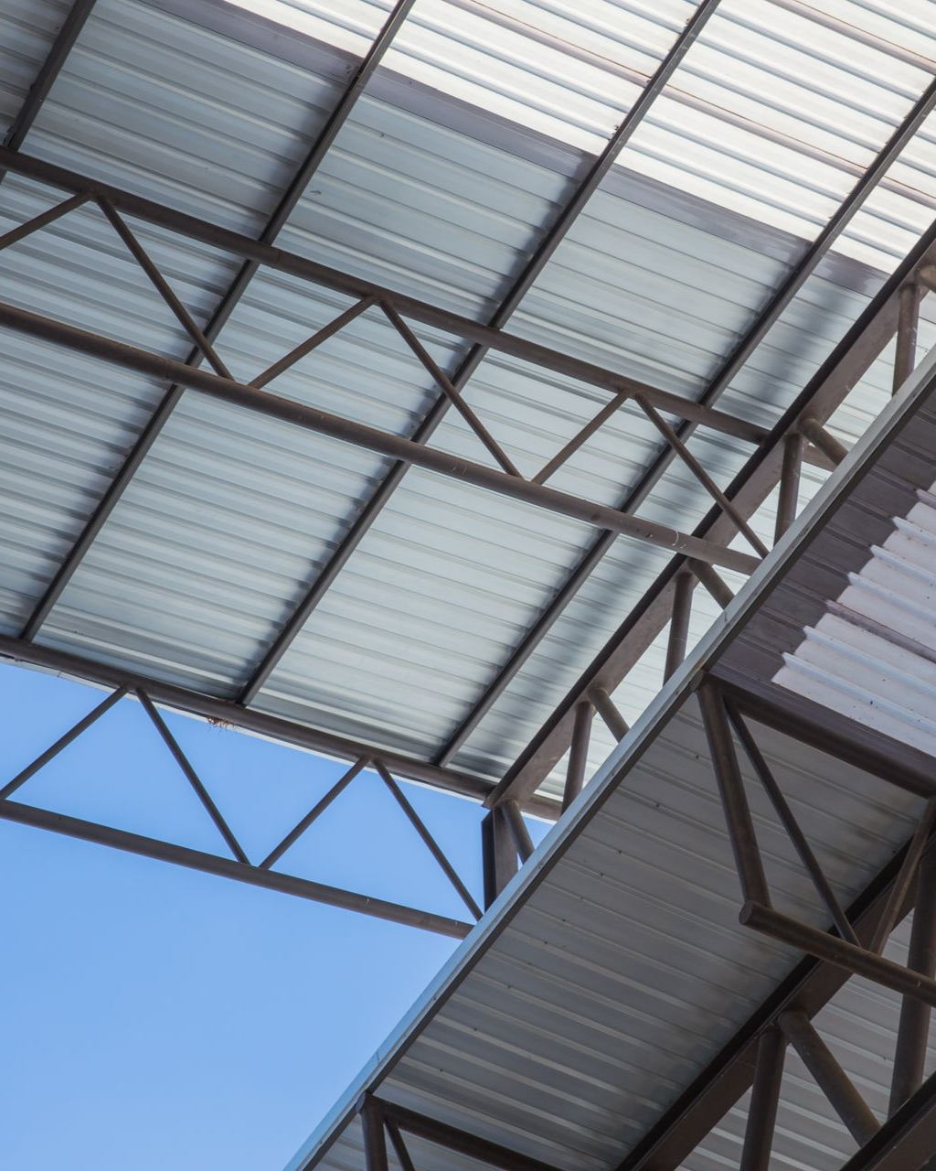 Toits en tôle ondulée et à ossature d'acier contre un ciel bleu.