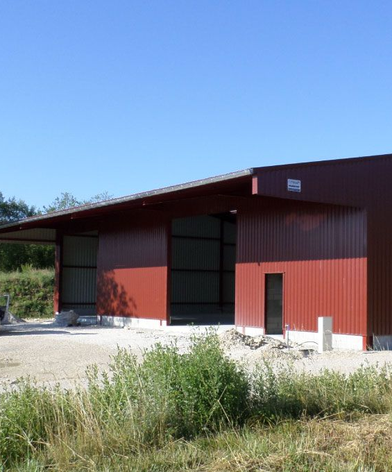 Balcon avec balustrades gris foncé, murs blancs et plantes en pot.