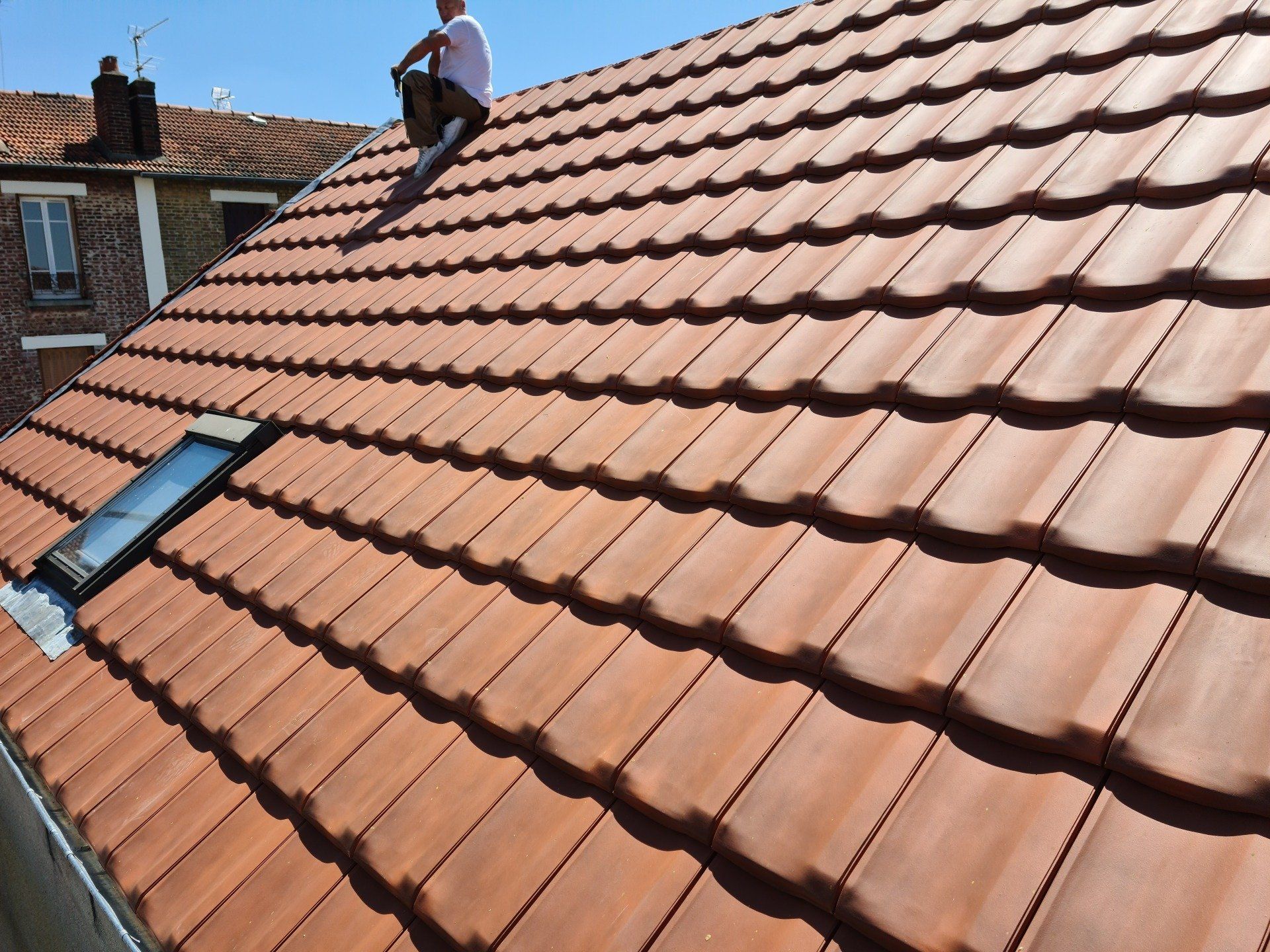 Toit entretenu avec un couvreur assis dessus