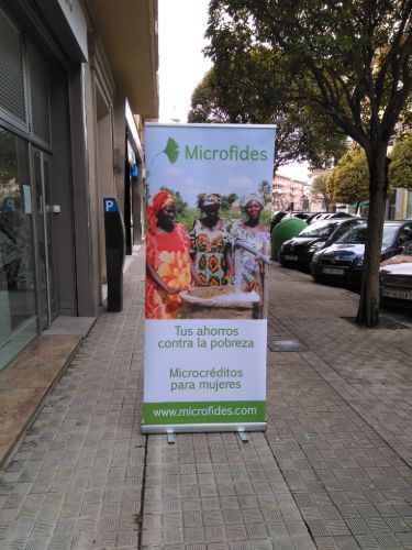 Una pancarta de Microfides está en una acera frente a un edificio.