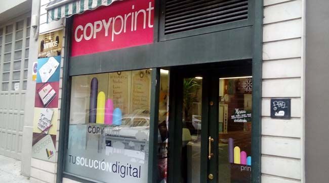 Una tienda de copias impresas con un cartel rojo