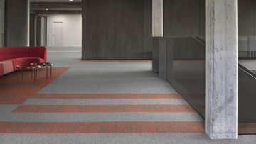 Una sala de estar con un sofá rojo y un suelo de rayas.