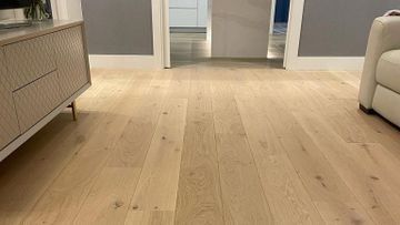 Una sala de estar con pisos de madera y un sofá.
