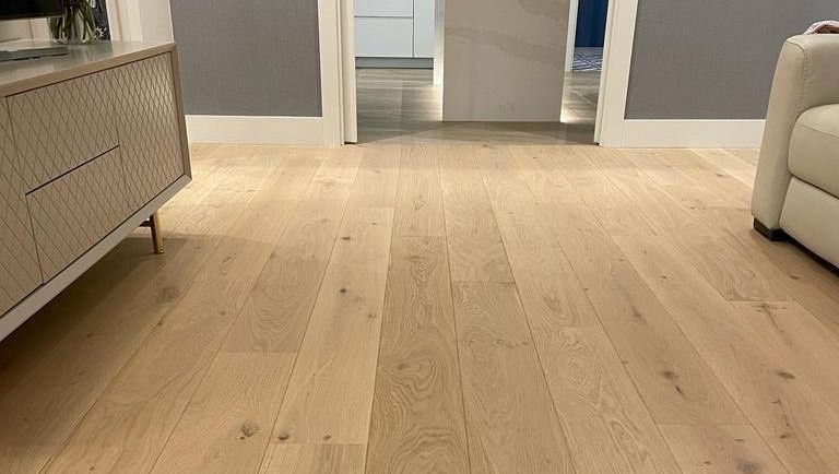 Una sala de estar con pisos de madera y un sofá.