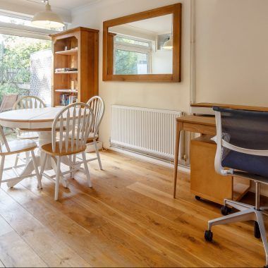 Una habitación con una mesa y sillas y un espejo en la pared.