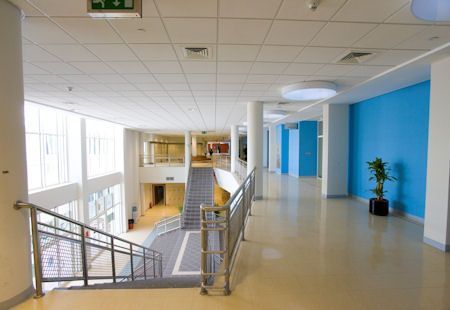 Un largo pasillo con escaleras que conducen al segundo piso de un edificio.