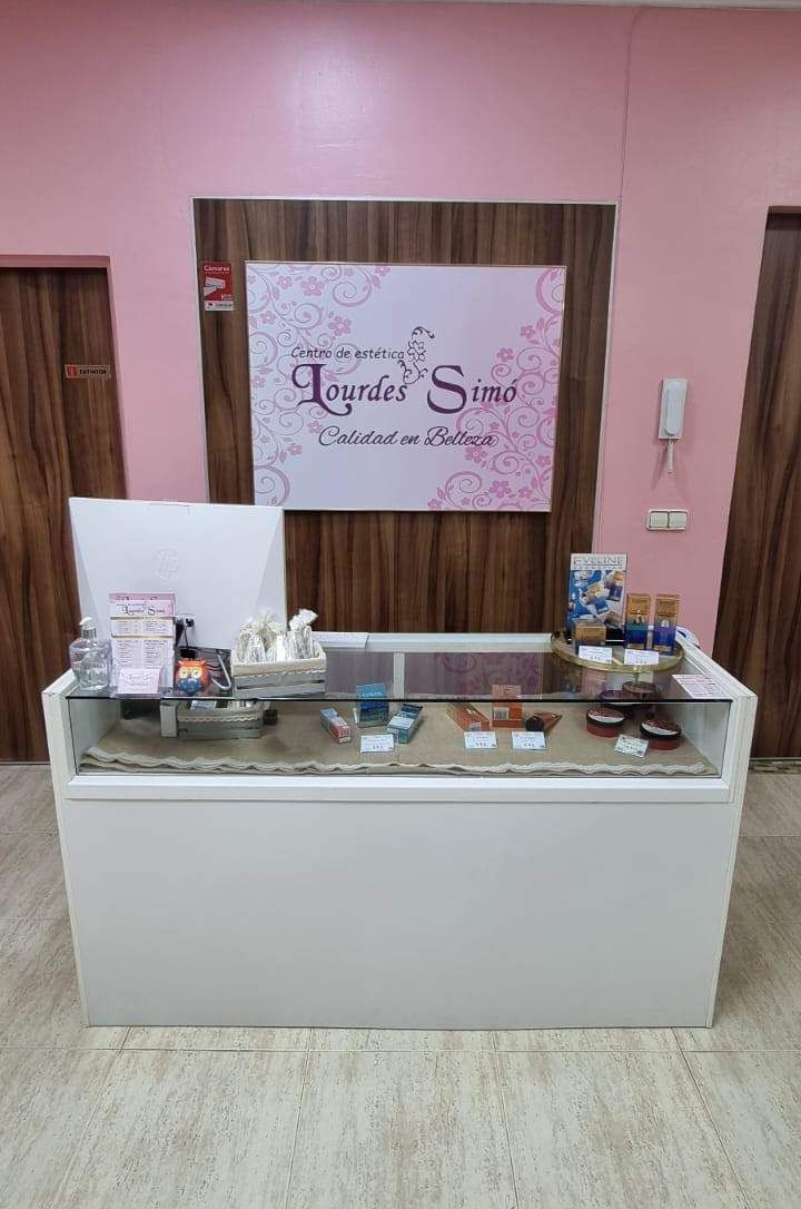 Un mostrador blanco con tapa de cristal se encuentra junto a una pared revestida de madera con un letrero de la tienda Lavender Scent.