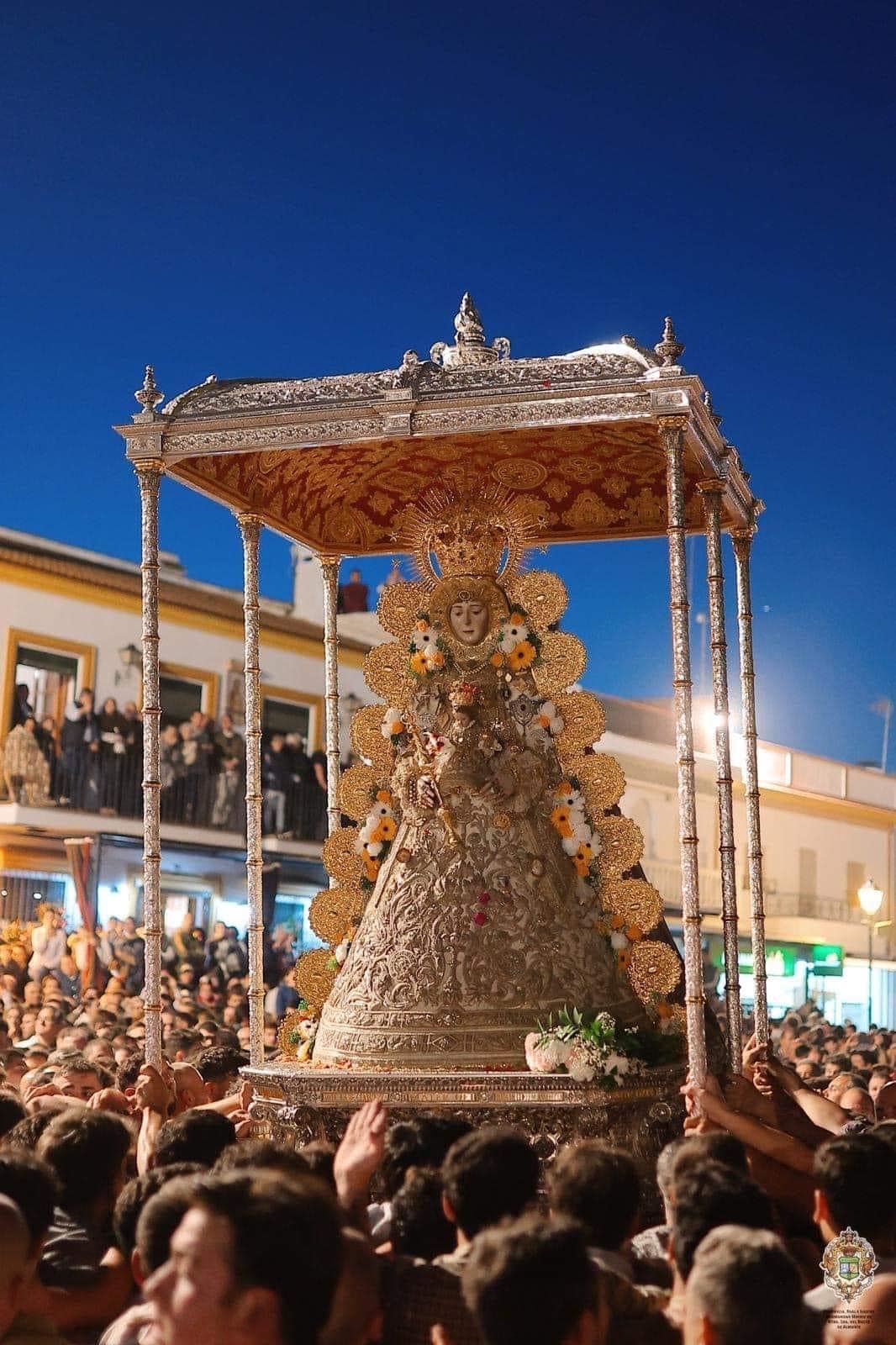 Procesión religiosa con una estatua de plata adornada de la Virgen