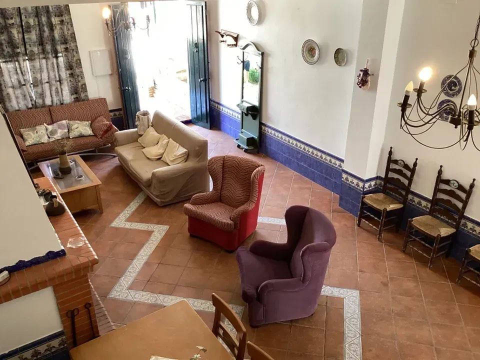 Sala de estar con sofás, sillones, sillas y chimenea. Asientos rojos,