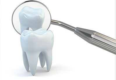 Un dentista examina un diente con un espejo.