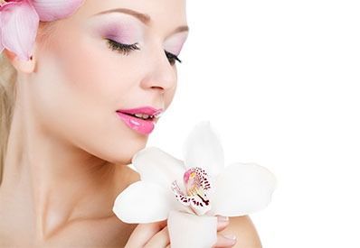Una hermosa joven sostiene una flor blanca en su mano.