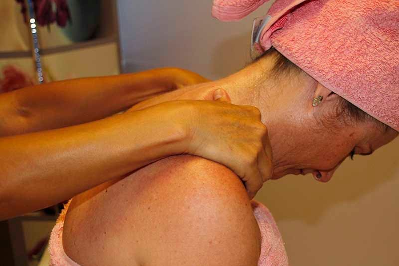 Una mujer con una toalla envuelta alrededor de su cabeza está recibiendo un masaje.