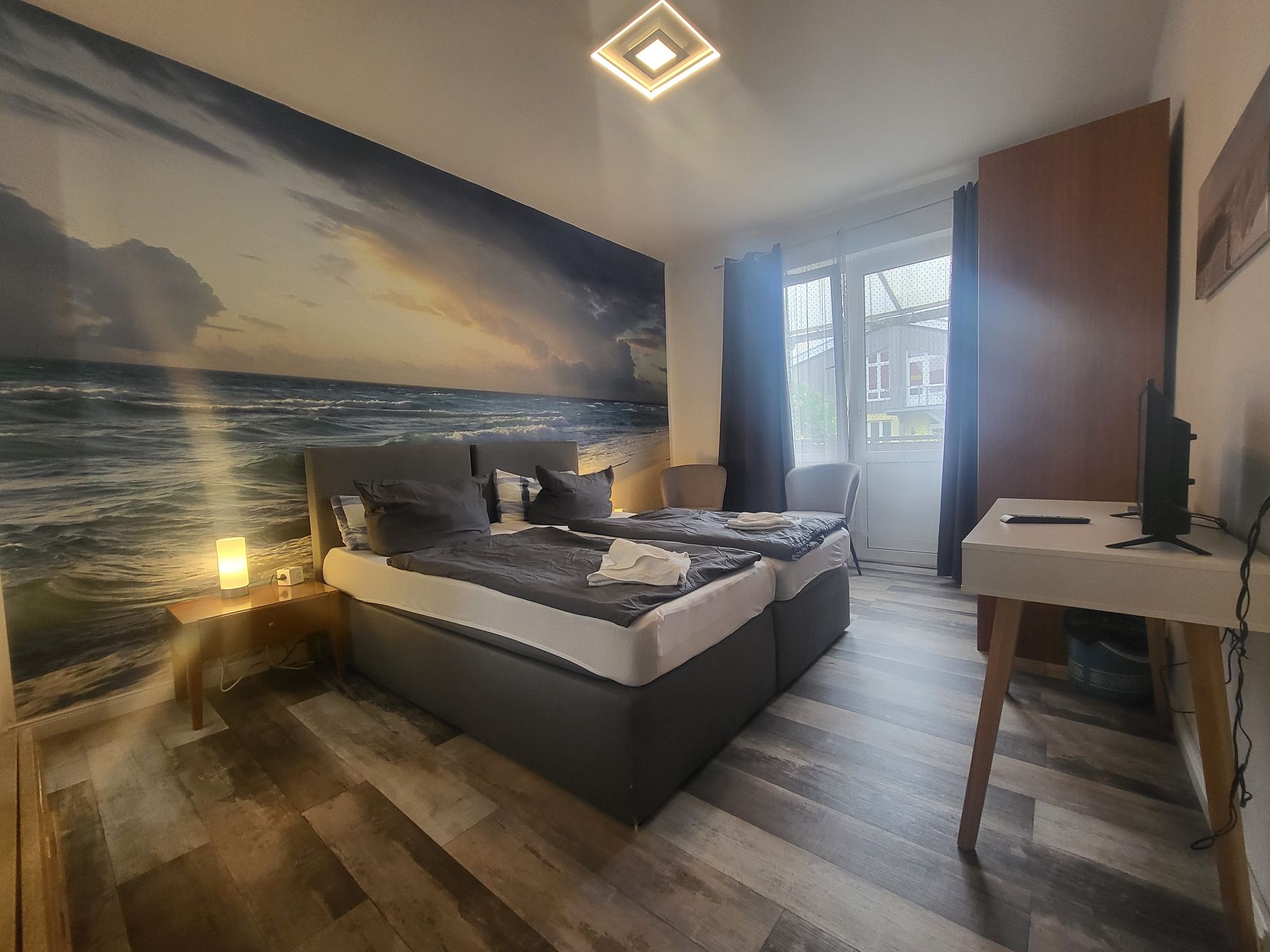 Ein Schlafzimmer mit zwei Betten, einem Schreibtisch und einem Fernseher.