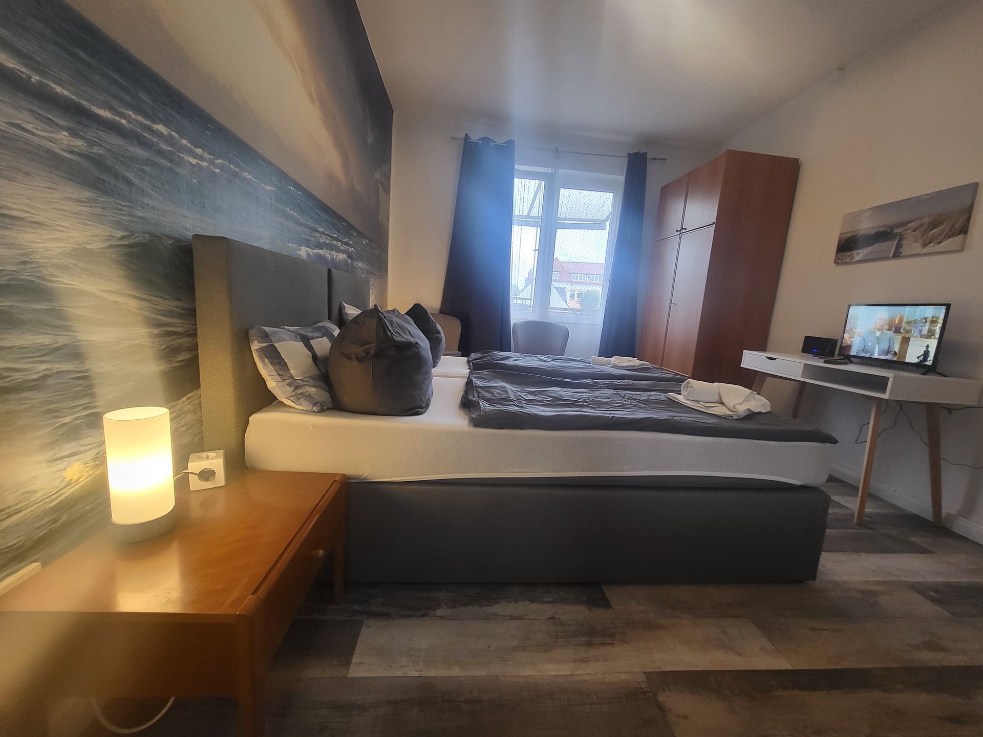 Ein Schlafzimmer mit zwei Betten, einem Schreibtisch und einem Laptop.