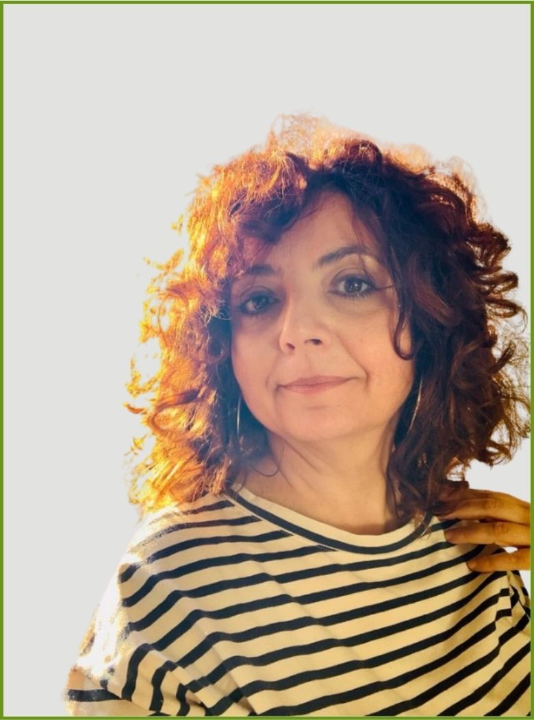Persona dai capelli ricci con una maglietta a righe bianche e nere su uno sfondo bianco brillante.