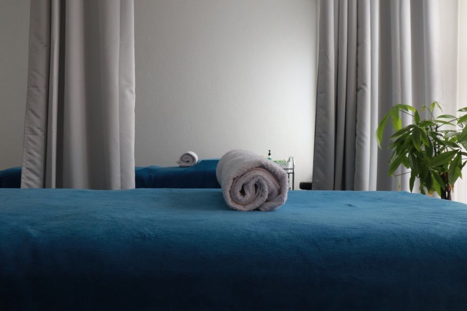 Zwei durch einen Vorhang getrennte Behandlungsliegen bei Kangjian Massage.