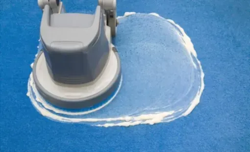 Monobrosse et produit moussant sur un sol de couleur bleue