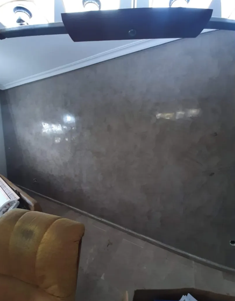 Interior de un autobús con suelo gris y asientos visibles cerca de las ventanas.