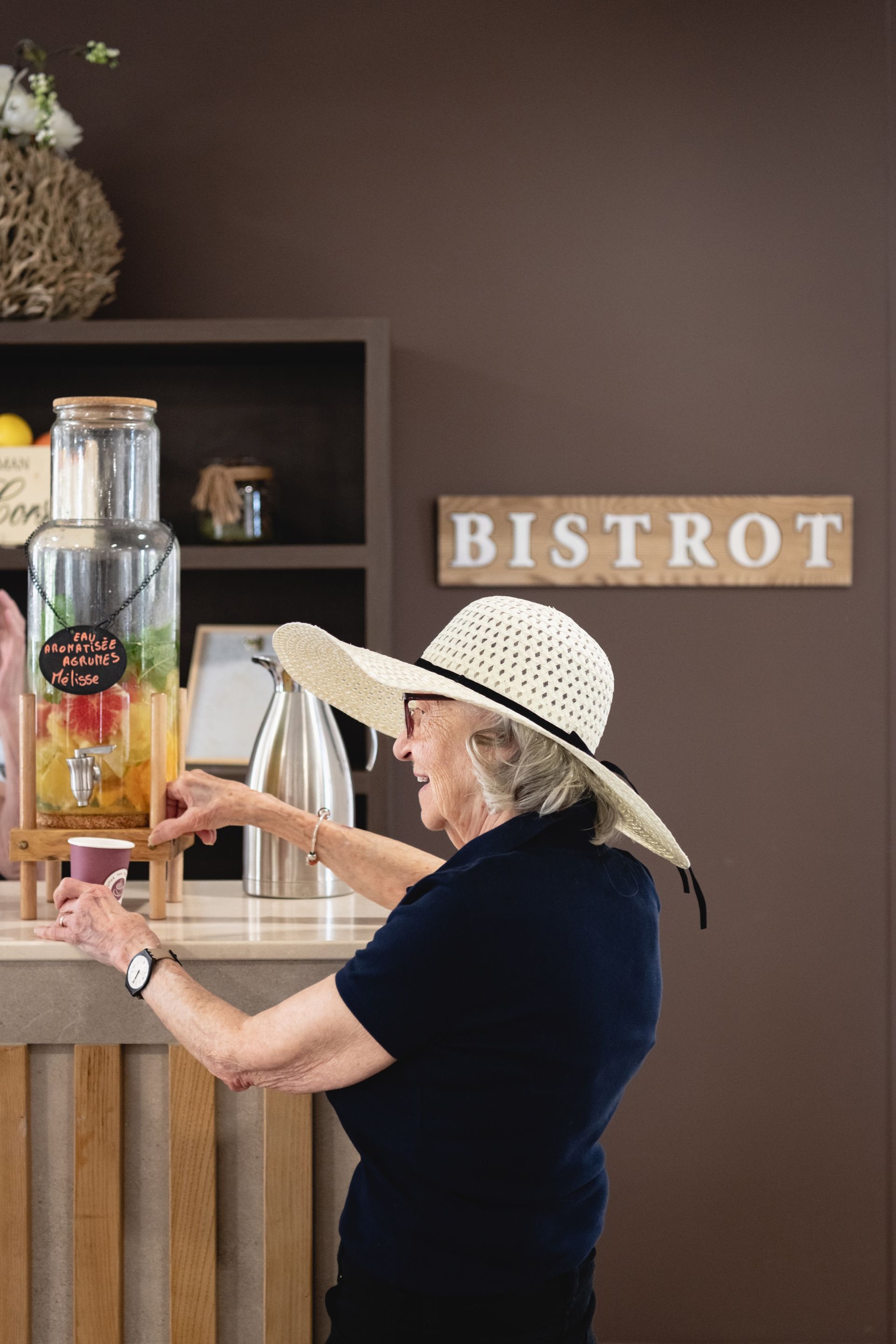 Une dame âgée qui se sert de l'eau aromatisée