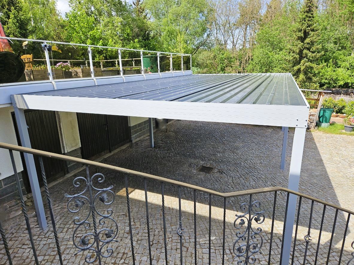 Ein Blick auf einen Carport von einem Balkon mit Metallgeländer.