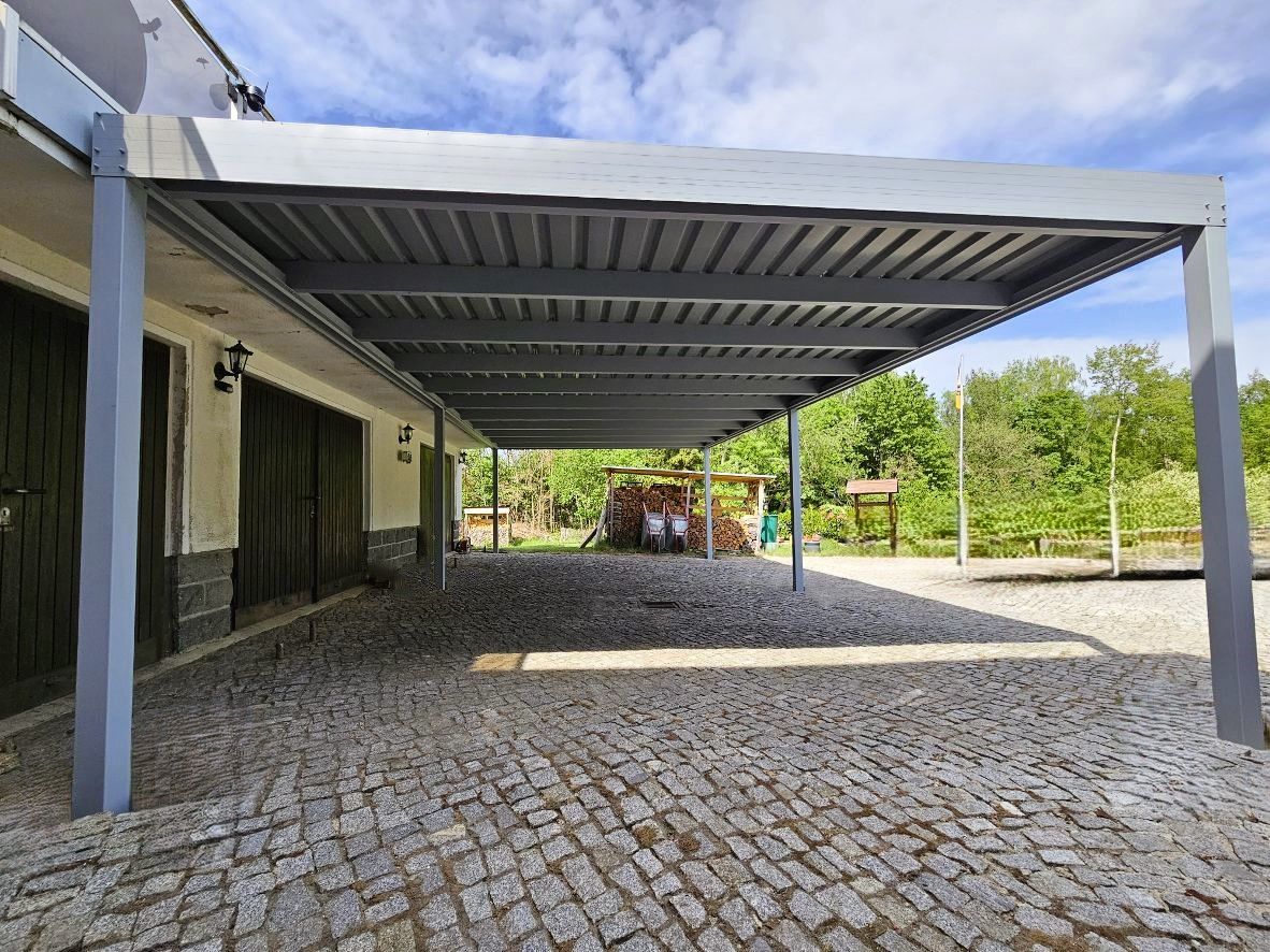 Vor einem Haus befindet sich ein Carport.
