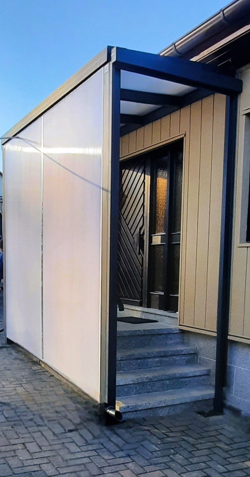 Ein Gebäude mit einem Vordach über dem Eingang und den Treppen.