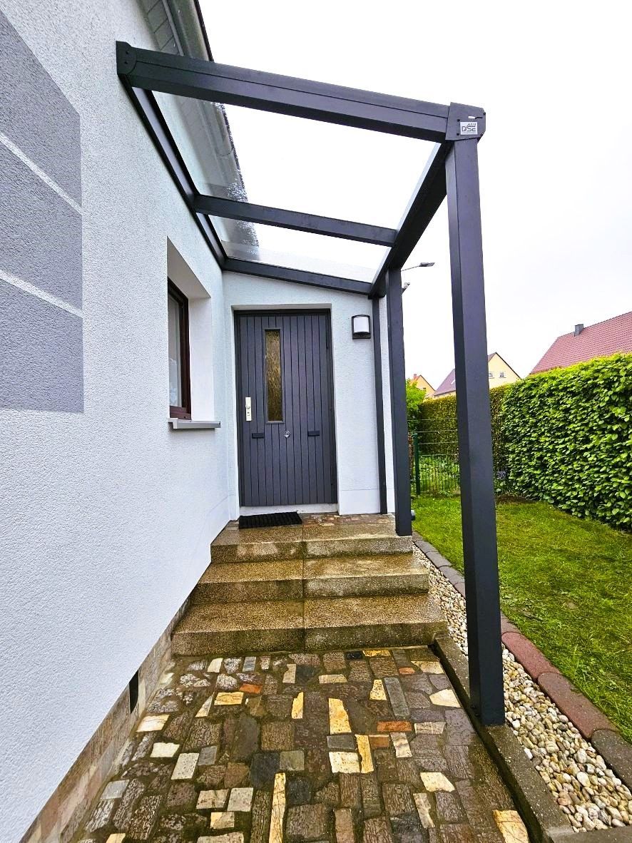 Es gibt eine Veranda mit einem Vordach über der Tür.