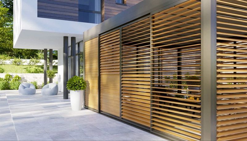 Ein modernes Haus mit einem Holzzaun und Glasschiebetüren.