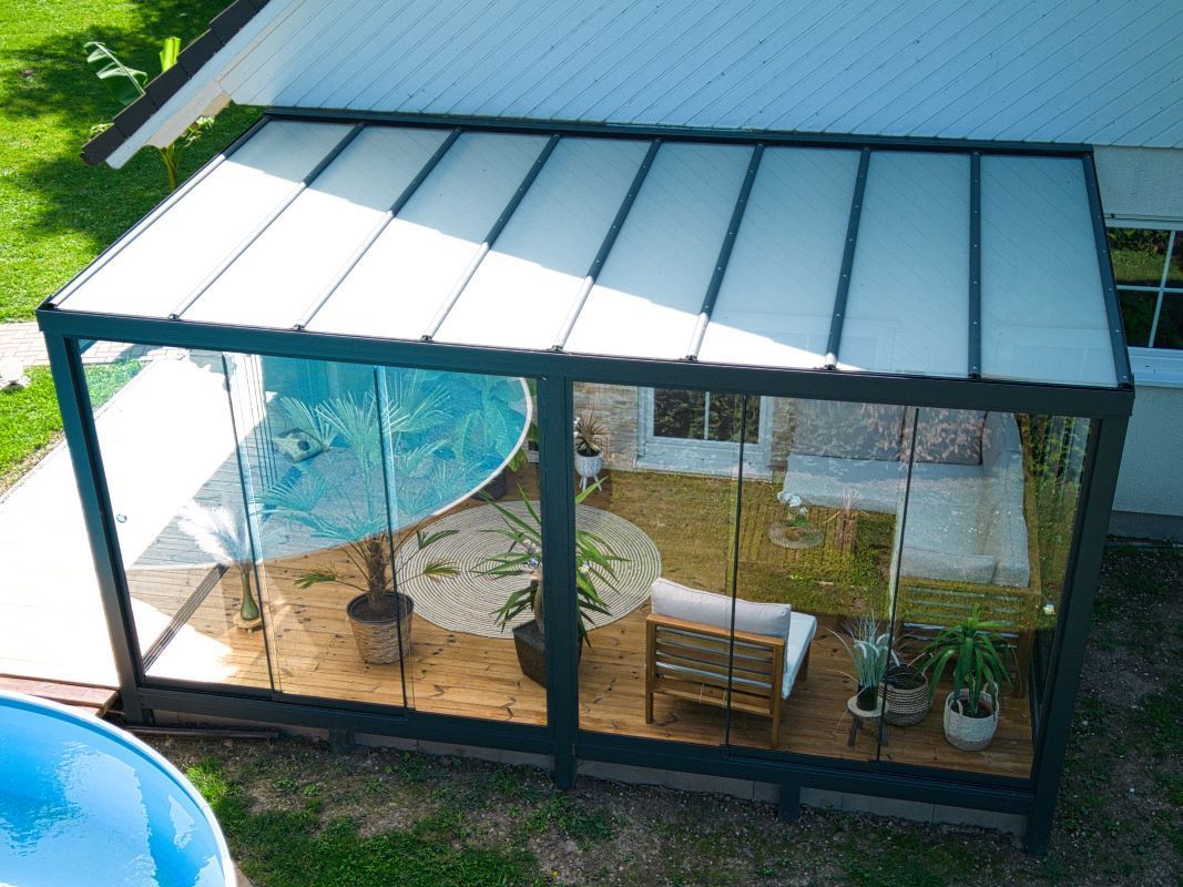 Eine Luftaufnahme eines Wintergartens mit einem Swimmingpool im Hintergrund.