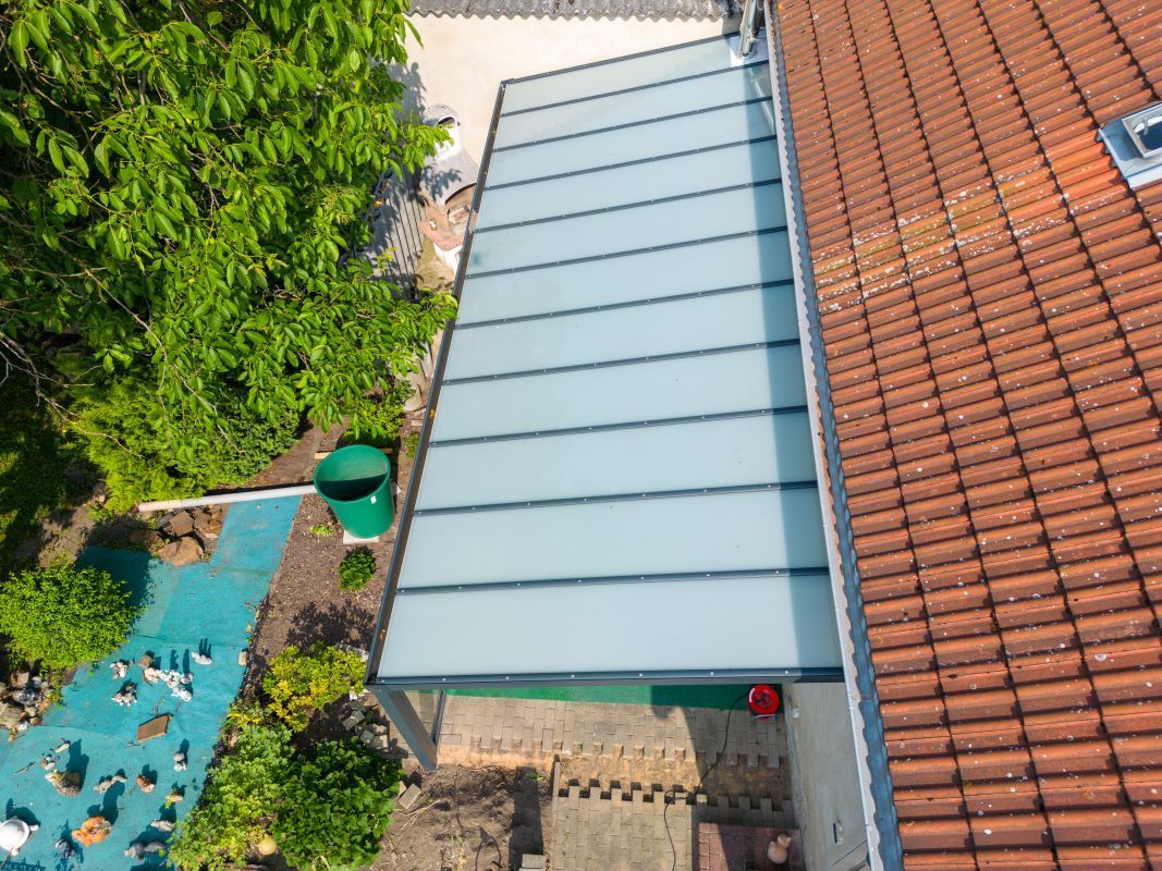 Eine Luftaufnahme eines Hauses mit Glasdach und Pool.